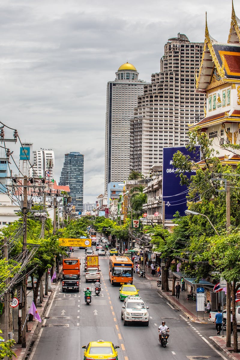 Bustling Bangkok street with traffic and iconic architecture. Urban life in Thailand's capital.